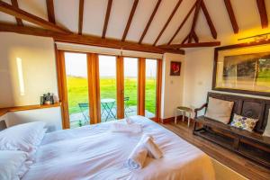 a bedroom with a large bed with towels on it at Dairyman's Barn -Rye - Countryside Retreat in Playden