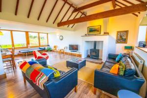 a living room with two blue couches and a fireplace at Dairyman's Barn -Rye - Countryside Retreat in Playden