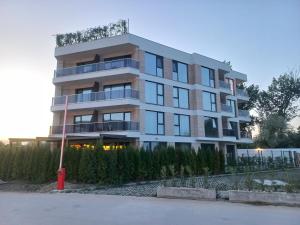 Un edificio alto y blanco con muchas ventanas. en Beach apartments Ema, en Kranevo