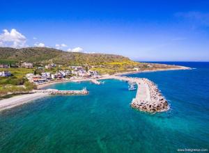 z powietrza widok na plażę z łodziami w wodzie w obiekcie Serenity Milatos w mieście Milatos