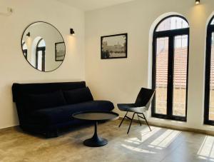 sala de estar con sofá, mesa y espejo en Lovely New Private Duplex in Prime City Center location, en Jerusalén