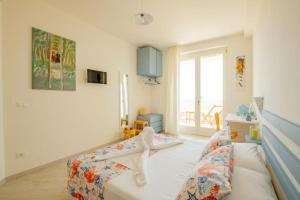 a bedroom with a bed with white sheets and a window at FinisTerrae Rooms and Suites in Gagliano del Capo