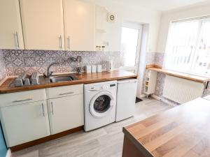 a kitchen with a washing machine and a sink at Mariai Eton Road in Mablethorpe