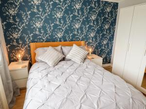 1 dormitorio con 1 cama grande y pared azul en Mariai Eton Road en Mablethorpe