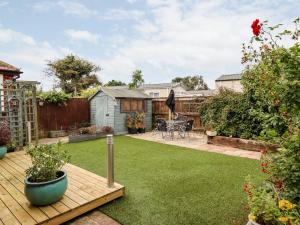 un pequeño jardín con terraza de madera y patio trasero en Mariai Eton Road en Mablethorpe