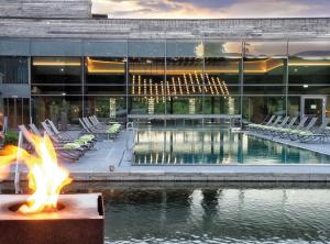 a pool in front of a building with a fire pit at Wellness & Naturresort Reischlhof in Wegscheid