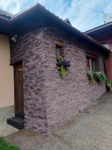 a brick house with flowers on the side of it at Apartmán Bianka in Rabča