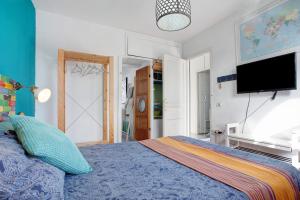 Schlafzimmer mit einem blauen Bett und einem Flachbild-TV in der Unterkunft Loft surfer'house in Corralejo