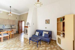 a living room with a blue couch and a kitchen at Villetta Dany by BarbarHouse in Torre Lapillo