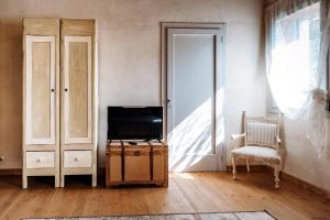 salon z telewizorem i krzesłem w obiekcie LOCANDA CONTA w mieście Piazzola sul Brenta