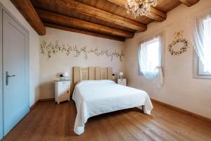 ein Schlafzimmer mit einem weißen Bett und einer Holzdecke in der Unterkunft LOCANDA CONTA in Piazzola sul Brenta