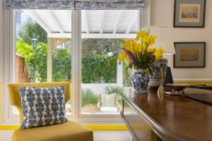 a kitchen with a desk with a vase of flowers and a window at Kouneni Apartments in Mikonos