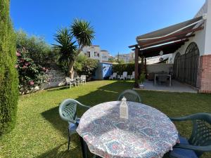 a patio with a table and chairs in a yard at Beach and Golf House La Cala de Mijas in La Cala de Mijas