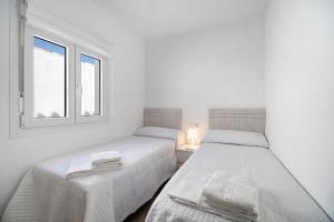 チクラナ・デ・ラ・フロンテーラにあるRchico Piscina climatizadaの窓のある白い部屋にベッドが2つある +29枚の写真