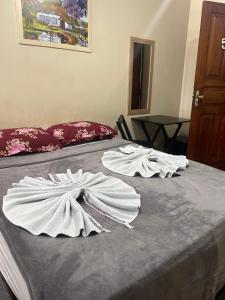 two white towels on top of a bed at Hotel Fortaleza Manaus in Manaus