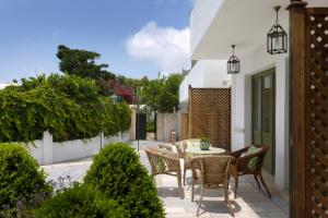 a patio with a table and chairs and plants at Kouneni Apartments in Mikonos