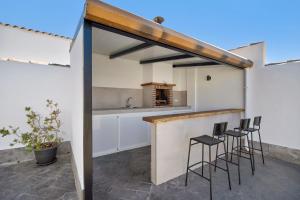 eine Küche mit einer Bar mit Hockern in der Unterkunft Rchico Piscina climatizada 1diciemb in Chiclana de la Frontera