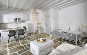 ein weißes Schlafzimmer mit einem Bett, einem Tisch und Stühlen in der Unterkunft CASA D'IRENE Mykonian residence in Mykonos Stadt