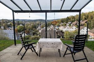 - une table et deux chaises sur une terrasse avec vue dans l'établissement Ferienwohnung Am Berg, Eheleute Müller, à Hilchenbach