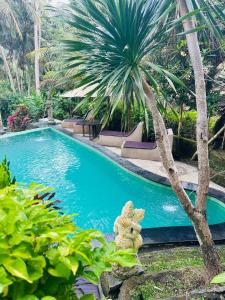 basen z palmą w ogrodzie w obiekcie Junjungan Suite w mieście Ubud