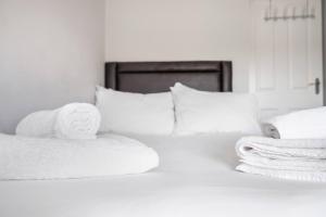 duas toalhas brancas em cima de uma cama em Glovers Lodge - Charming 3 Bed Retreat near City Centre em Derby