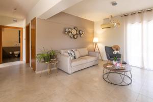 a living room with a couch and a table at Dioni Pool House in Ialyssos