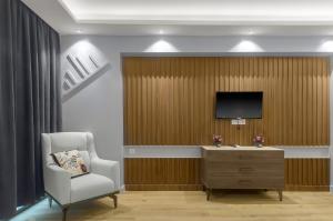 a room with a chair and a television on a wall at Beachfront Batumi View Apartments by GLOBALSTAY in Batumi