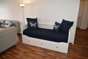 ein Bett mit Kissen und ein Sofa in einem Zimmer in der Unterkunft Haus Heß Ferienwohnung Nr 07 in Niendorf