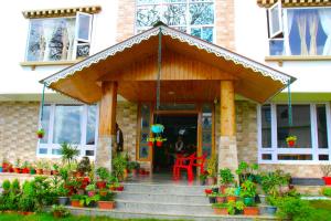 een veranda aan de voorzijde van een huis met een rode stoel bij 9 Senses Group hotels , Ravangla in Ravangla