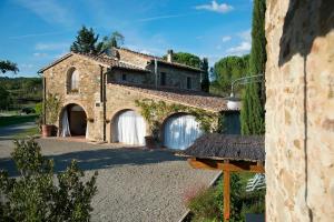 an external view of a stone house with a garage at Agriturismo Piettorri in Casole dʼElsa