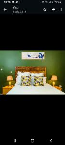 a bedroom with a bed with two lamps and a green wall at Birdville BNB Guest House in Gaborone
