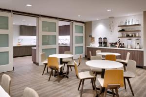 comedor con mesas y sillas y cocina en Residence Inn by Marriott Phoenix West/Avondale, en Avondale