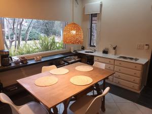 uma cozinha com uma mesa de madeira com cadeiras e uma janela em La Posadita de Chacras em Chacras de Coria