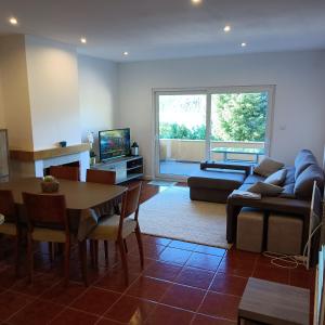 a living room with a couch and a table and a tv at AQUAVIEW - VENDA NOVA in Venda Nova
