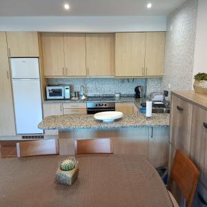 a kitchen with a table and a white refrigerator at AQUAVIEW - VENDA NOVA in Venda Nova