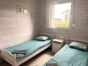 2 camas individuales en una habitación con ventana en Domki Laba, en Łeba