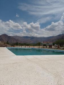 a swimming pool in the middle of a desert with mountains at Cabañas Cafayate I in Cafayate