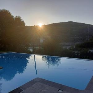 a swimming pool with the sun setting in the background at AQUAVIEW - VENDA NOVA in Venda Nova