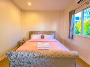 a bedroom with a bed with an orange comforter and a window at Himehome at Suanbanpaeng 