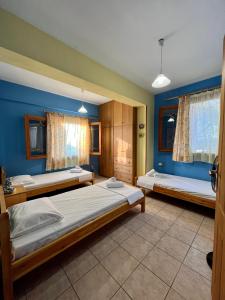 2 łóżka w pokoju z niebieskimi ścianami i oknami w obiekcie Filoxenia Residence 