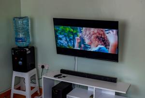 einen Flachbild-TV, der an einer Wand hängt in der Unterkunft Nsos apartment in Busia