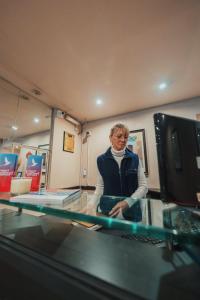 a woman is standing behind a glass counter at Apartur Buenos Aires in Buenos Aires