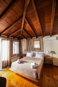 una camera da letto con un grande letto e soffitti in legno di Dohos Nature Guest House a Karítsa