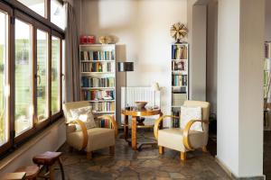 un soggiorno con sedie, tavolo e librerie di Dohos Nature Guest House a Karítsa