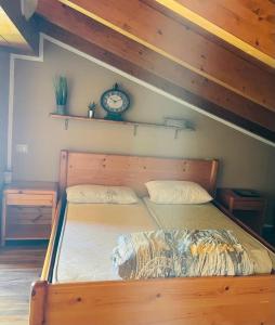 a bedroom with a wooden bed with a clock on the wall at Homesweethome in Porto Torres