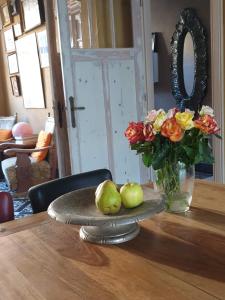 a table with a vase of flowers and pears on it at Bed & Breakfast Exterlaer in Antwerp