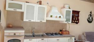 a kitchen with a sink and a stove top oven at Casa di Dario in Pettenasco