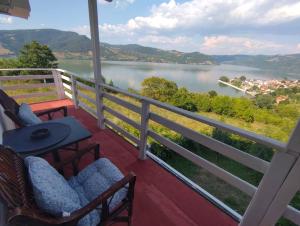 a balcony with chairs and a view of a lake at Marković Apartments (vidikovac) in Donji Milanovac