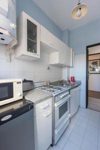 uma cozinha com electrodomésticos brancos e armários brancos em Apartur Buenos Aires em Buenos Aires