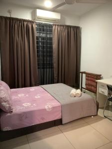 ein Schlafzimmer mit einem Bett mit zwei Handtüchern darauf in der Unterkunft Dwiputra Presint 15 at Putrajaya in Putrajaya